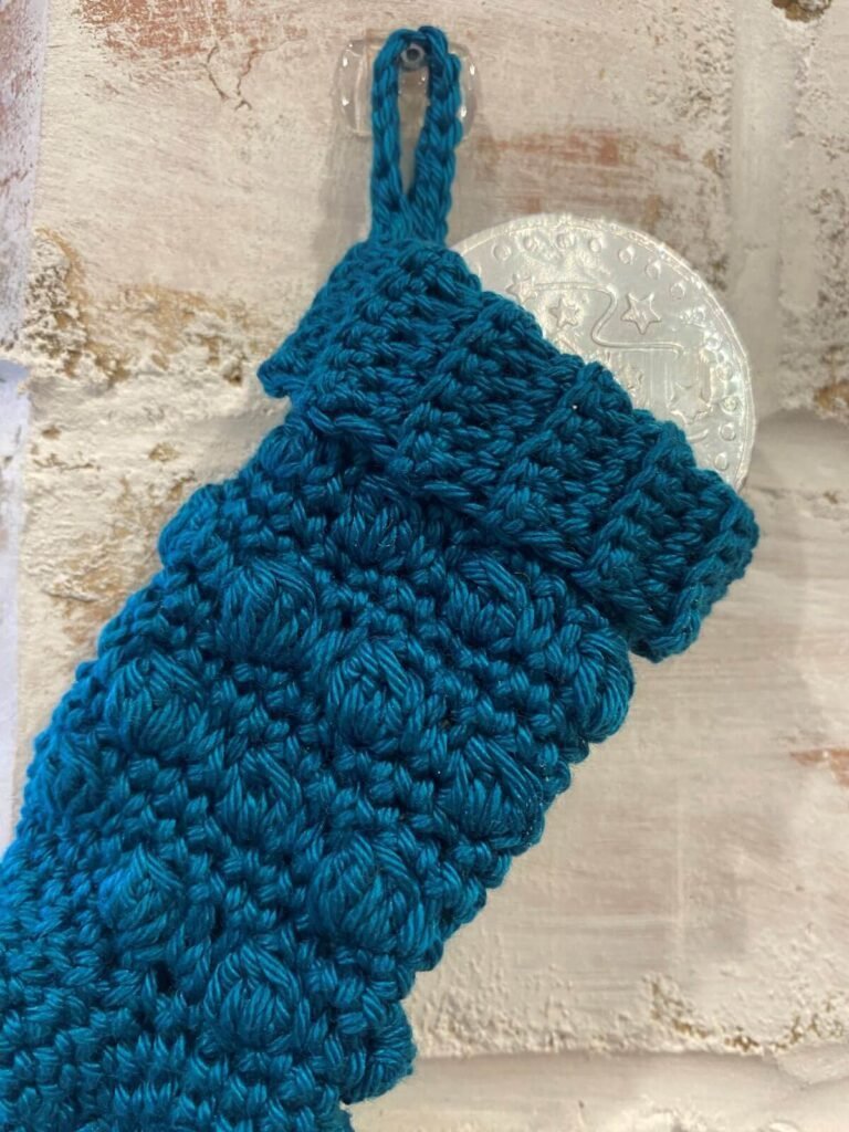 close up of a blue stocking with a chocolate coin in it