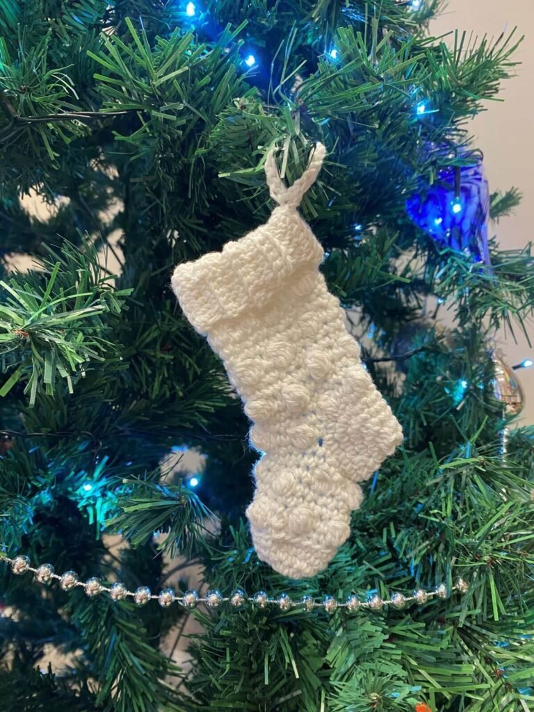 White mini stocking hanging on a tree