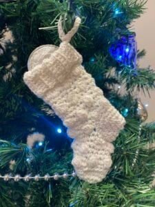 Mini crocheted chocolate stocking hanging on a tree