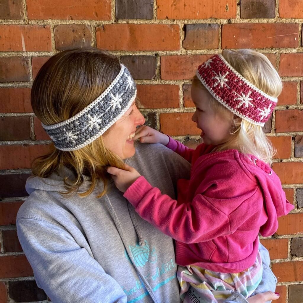Mum and child looking at each other wearing snowflake crochet headbands