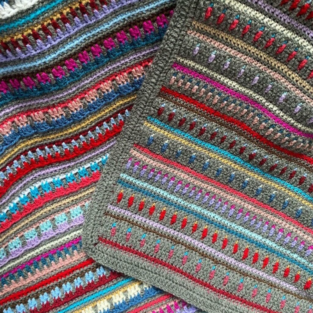 close up of 2 sides of a reversible multi-coloured blanket