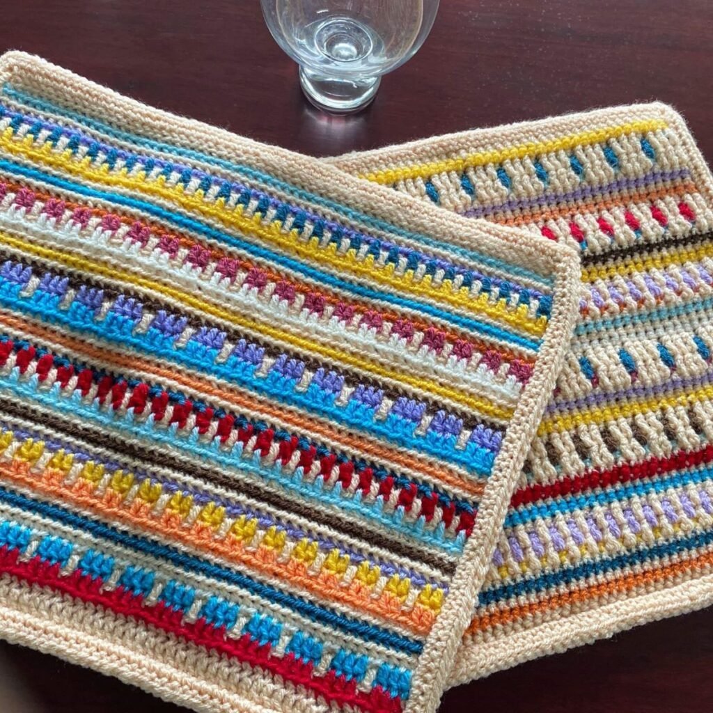 2 reversible mosaic crochet placemats overlapping each other