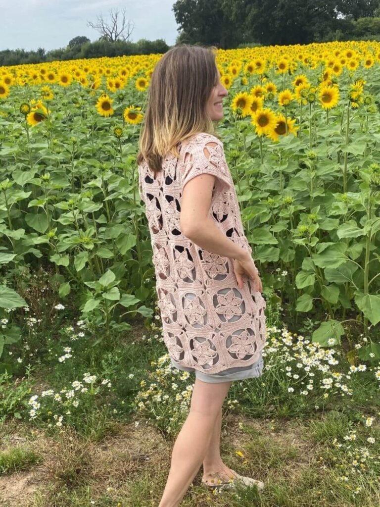 A lady with her back turned wearing a beige crochet lace cardigan
