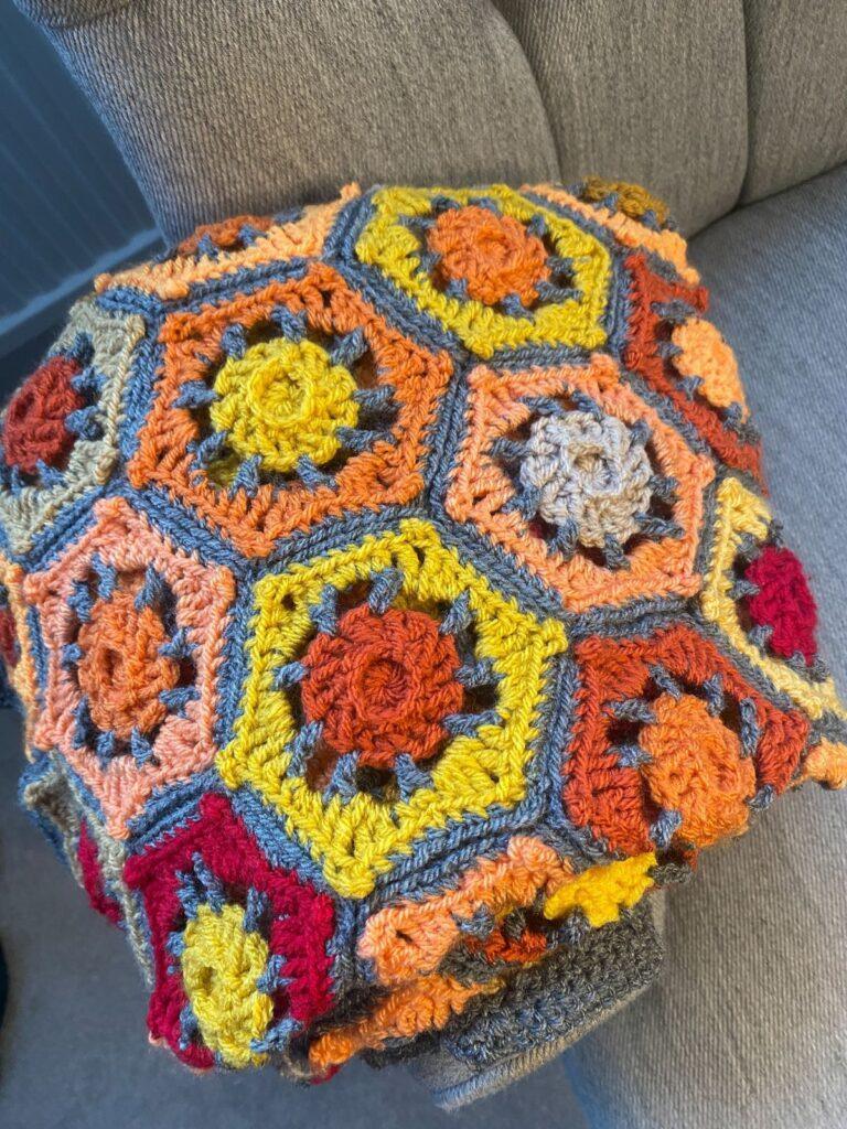 A top view of a hexagonal crochet blanket on a chair