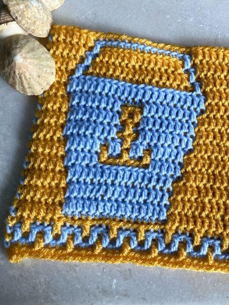 close up of an overlay mosaic crochet pattern of a bucket with an anchor on