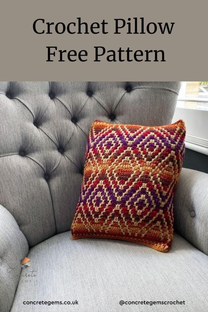 A bright colourful crochet pillow sits on a grey wingback chair