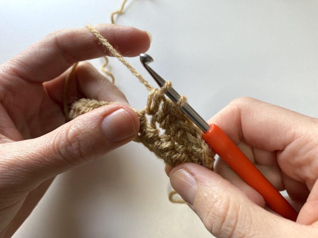 step 4 of the crochet pique stitch: yarn over and pull through 2