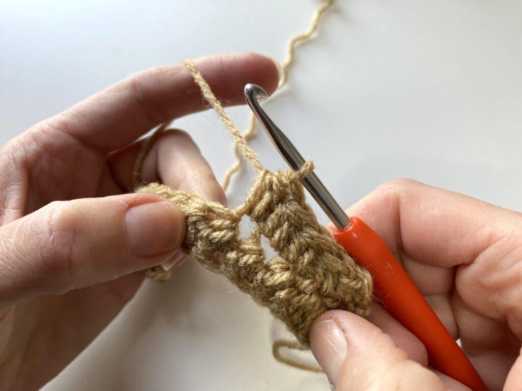 final step 8 of the pique stitch made with beige yarn and orange crochet hook