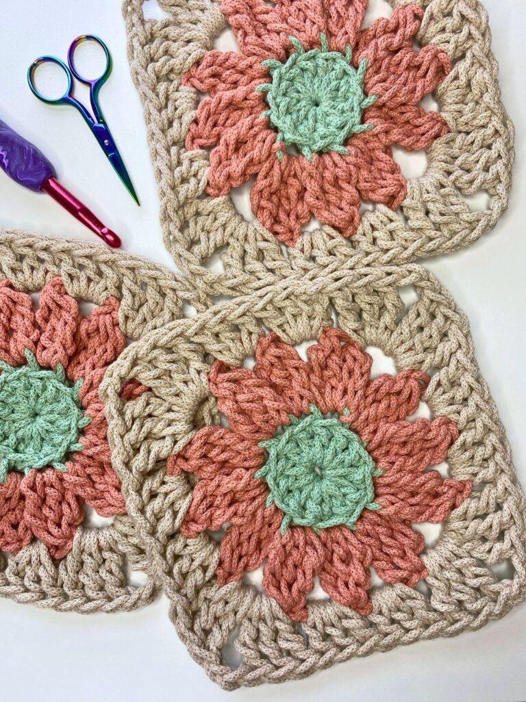 3 granny squares that look like flowers, some scissors and a crochet hook