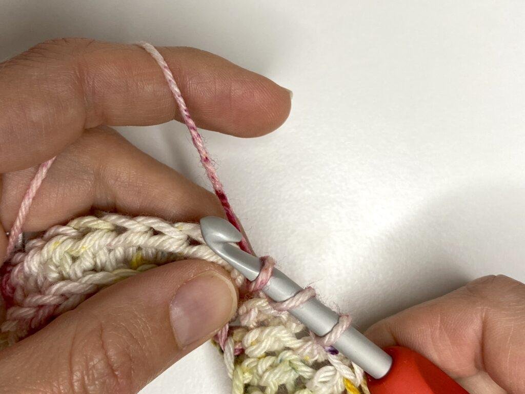 A crochet sample of half double crochet in the third loop showing 3 loops on the hook