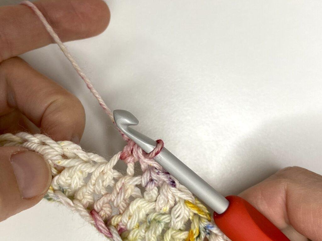 A person has just completed a half double crochet stitch