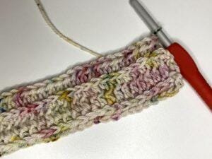 A crochet sample and hook of half double crochet in the third loop