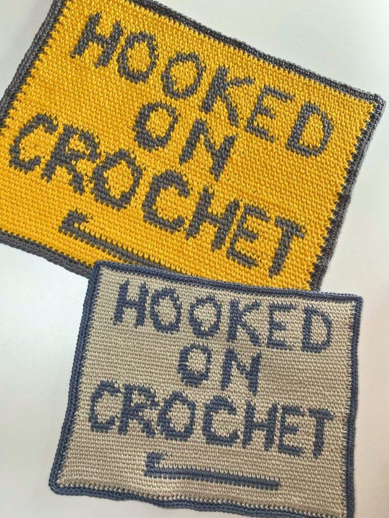 2 pieces of crochet wall art are laid out on top of each other. One is blue and beige, the other yellow and grey. Both feature the words 'hooked on crochet'