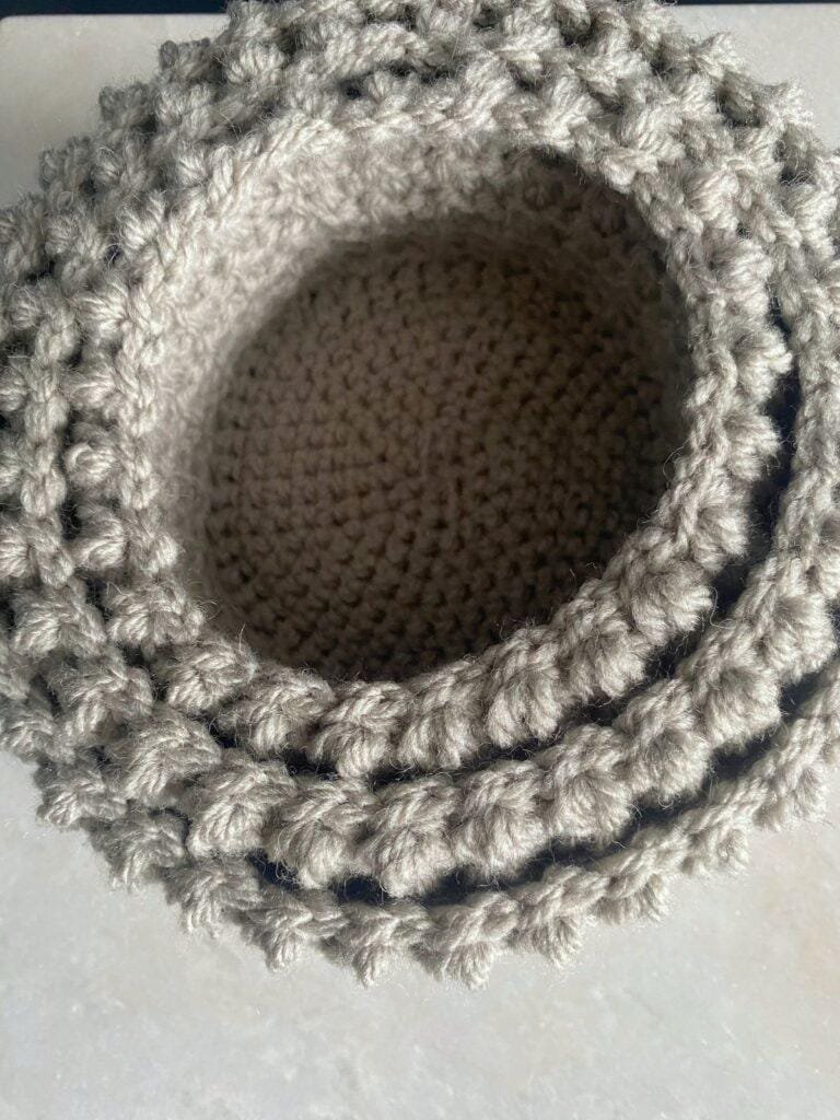 3 crochet grey baskets stacked inside one another, looked at from the top down
