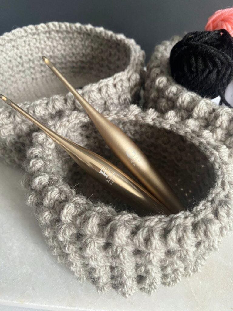 3 crochet bobble baskets with 2 crochet hooks in the closest basket.