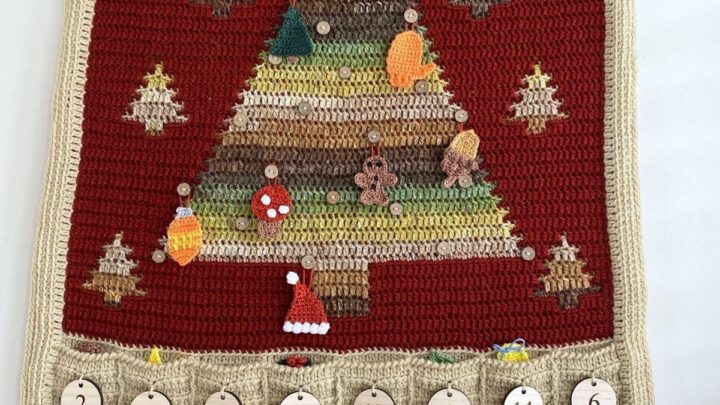 A crochet advent calendar with a Christmas tree, pockets underneath and hanging decorations on the tree