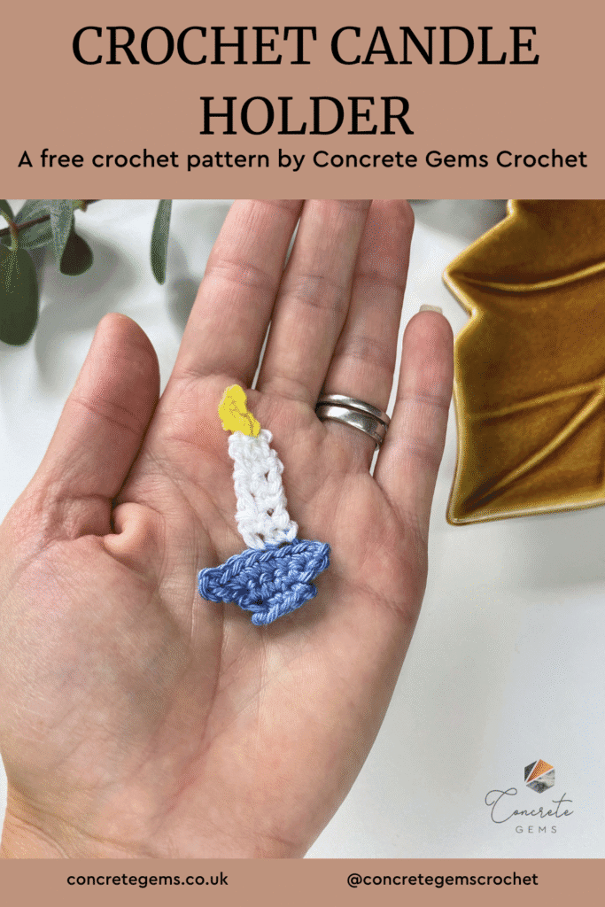 A hand holds a tiny crochet candle with a blue holder and behind is a brown leaf shaped dish