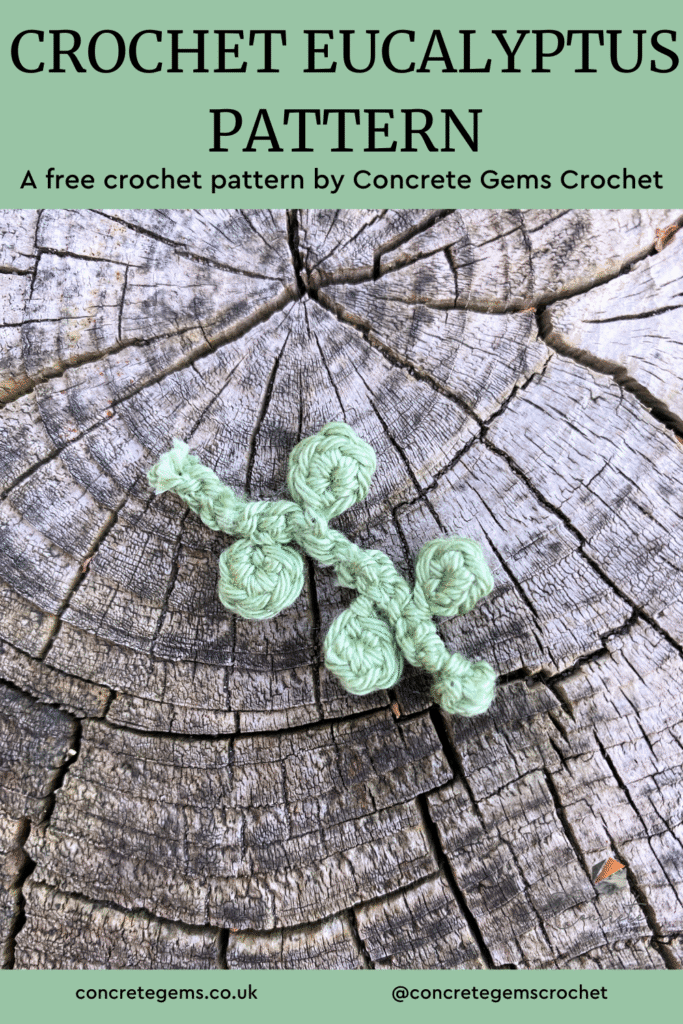 A tiny crochet eucalyptus pattern lays on a wooden slice with the words CROCHET EUCALYPTUS PATTERN above