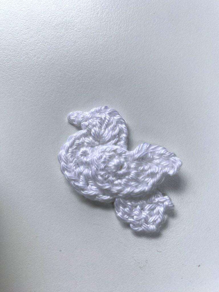 A white crochet dove on a white background
