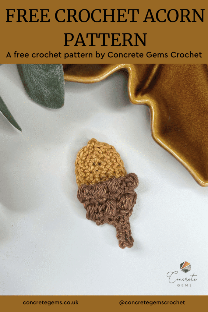A crochet acorn lays on a white background with a brown leaf shaped dish and a green leaf at the edge and the words FREE CROCHET ACORN PATTERN above