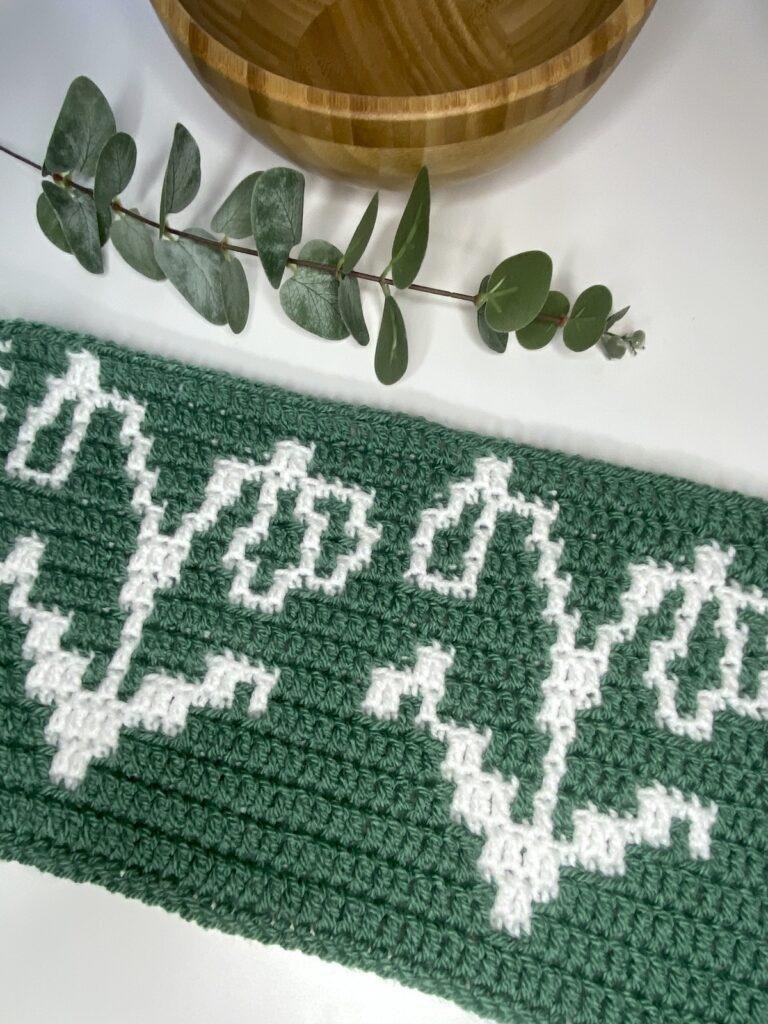 A green and white mosaic crochet sample features 2 crochet snowdrop motifs