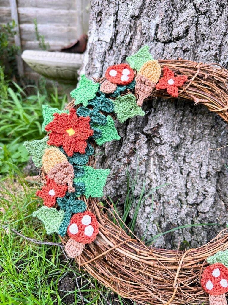 A close up of a woodland wreath with rattan base and crochet motifs.