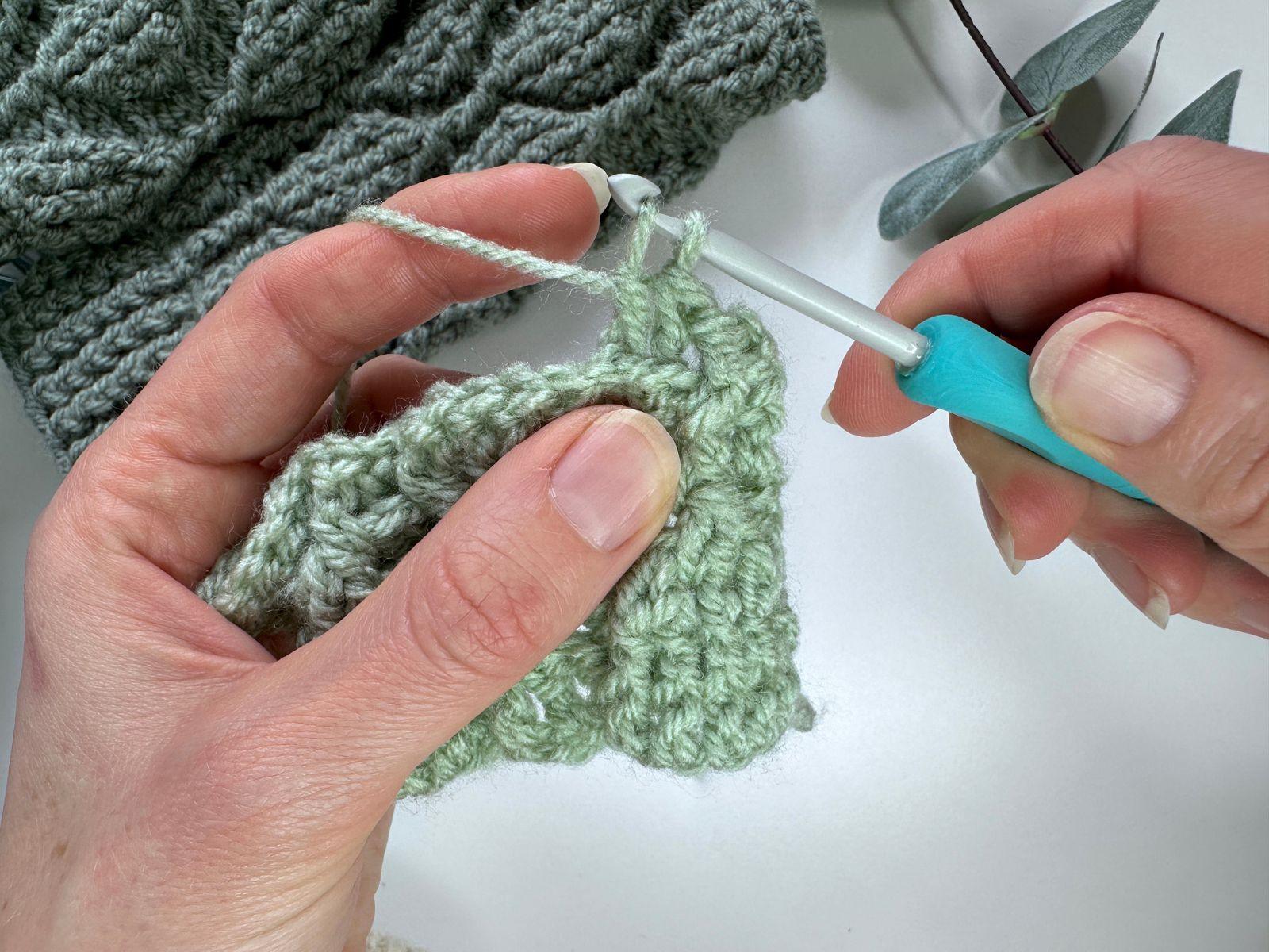 A crocheter's hands show that there are 2 loops on the loop when making a stitch