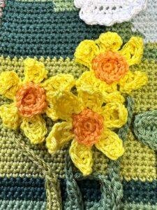 3 crochet daffodil flowers on a green background