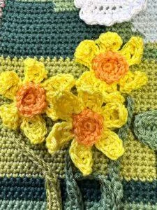 3 crochet daffodil flowers on a green background