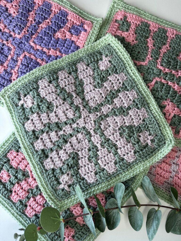 A messy pile of mosaic crochet flower squares in different colours