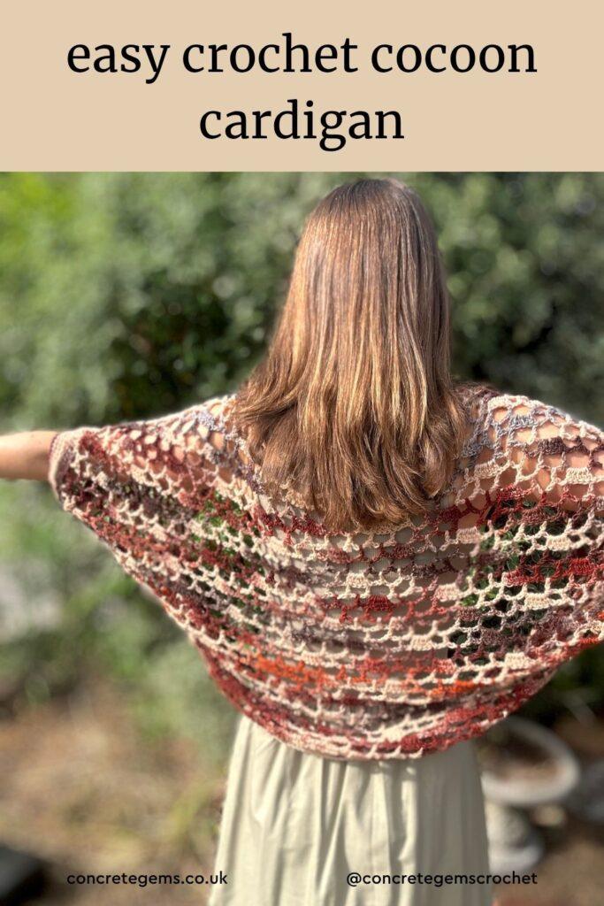 A woman with her back to the camera and arms outstretched wears a variegated brown crochet cocoon cardigan