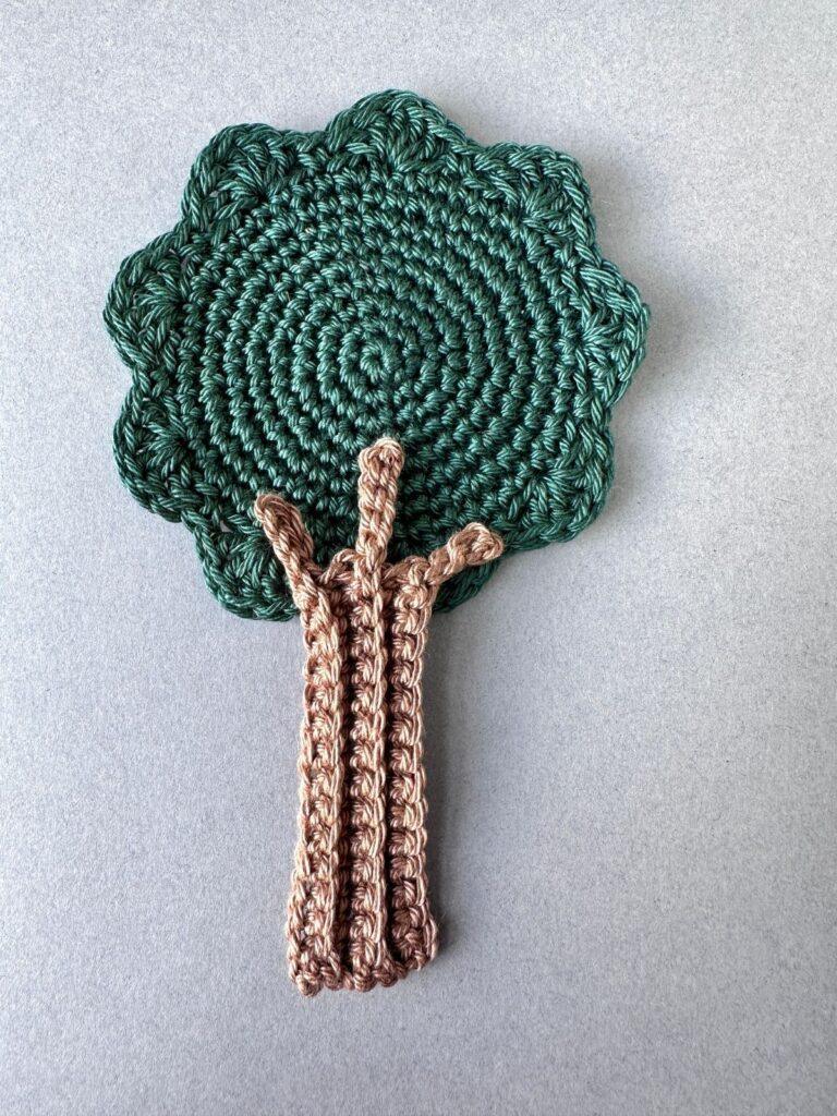 A flat crochet tree pattern is on a grey background