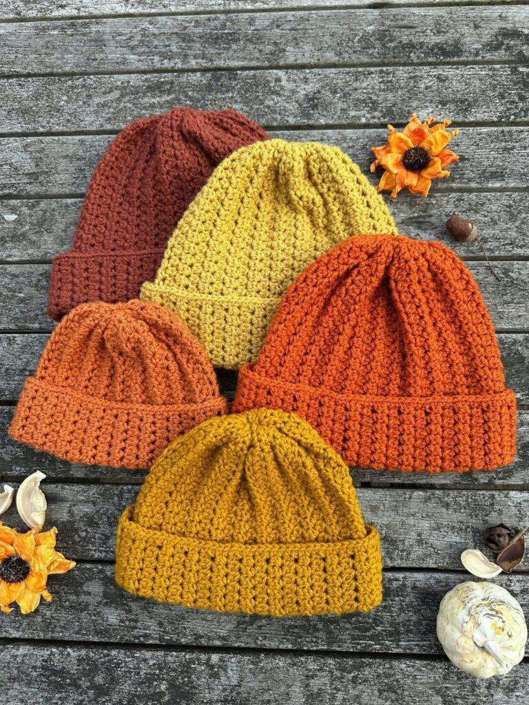 5 crochet beanie hats in different colours and sizes reminiscent of fall