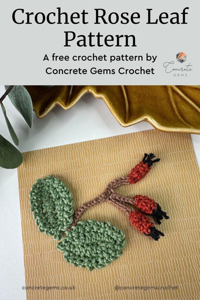 A pin for a crochet rose leaf pattern showing 2 rose leaves and a rose hip sprig in crochet