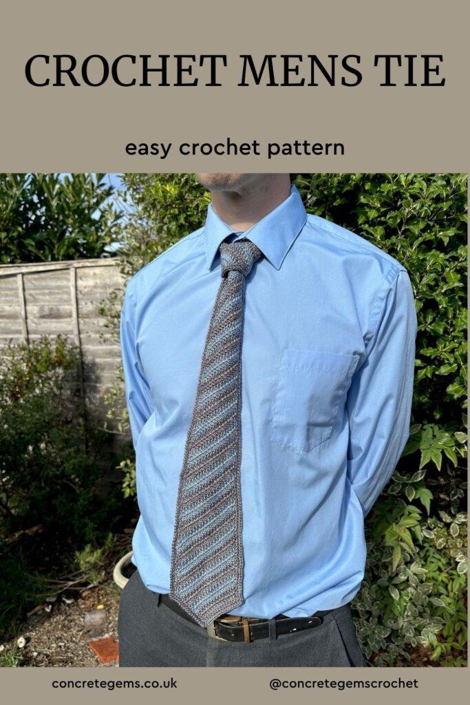 The torso of a man wearing a blue shirt and a blue and grey crochet men's tie